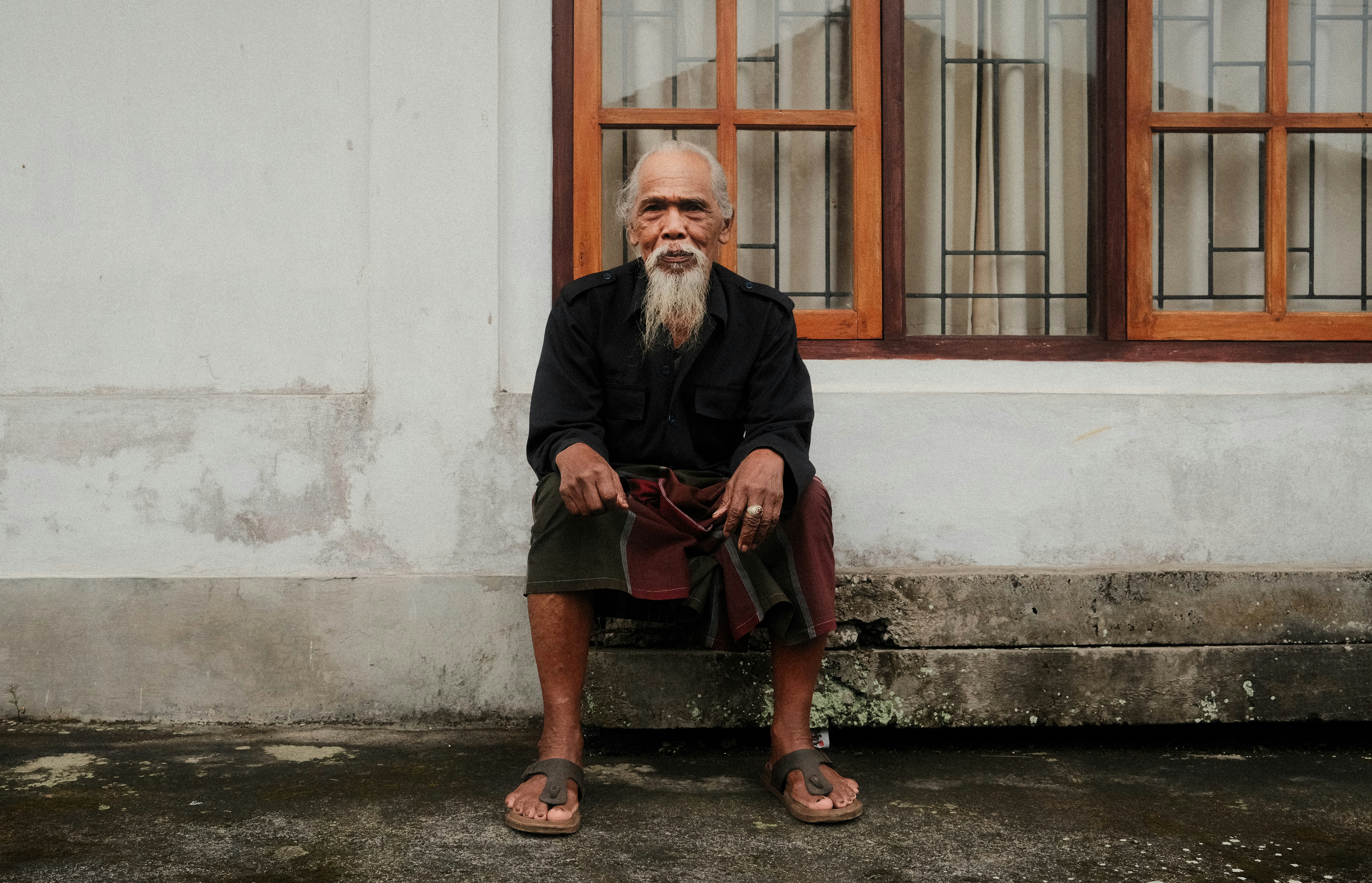 Candid portrait of a man sitting on the curb